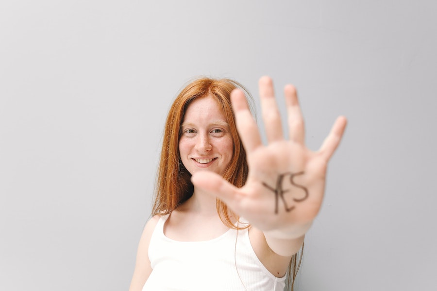 Eine Frau zeigt ihre mit 'Yes' beschriftete Hand